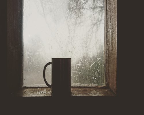 Morning coffee cup near a bright window with morning light